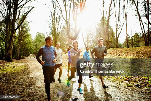 Smiling friends running together in park Smiling friends running together in park