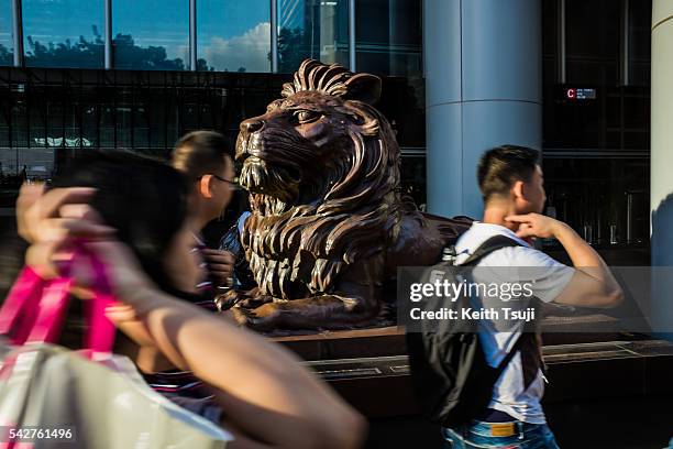 People walk in front of the HSBC Holdings plc headquarters building on June 24, 2016 in Central, Hong Kong. The result from the historic EU...