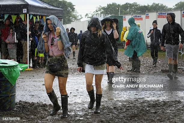 Festival-goers brave the mud and rain on day three of the Glastonbury Festival of Music and Performing Arts on Worthy Farm near the village of Pilton...