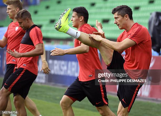 Poland's forward Robert Lewandowski and his teammates take part in a training session at the Geoffroy Guichard stadium in Saint-Etienne on June 24,...