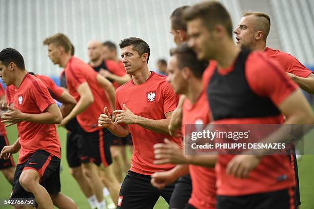 Poland's forward Robert Lewandowski and his teammates take part in a training session at the Geoffroy Guichard stadium in Saint-Etienne on June 24,...