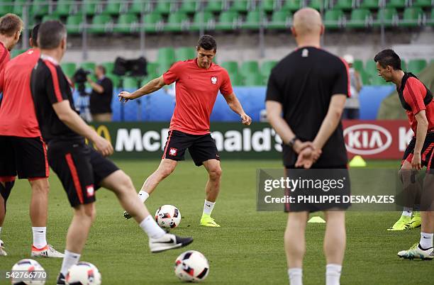 Poland's forward Robert Lewandowski and his teammates take part in a training session at the Geoffroy Guichard stadium in Saint-Etienne on June 24,...