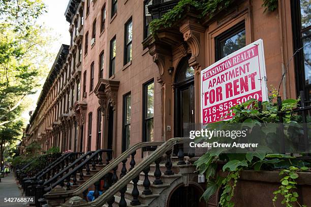 Sign advertises an apartment for rent along a row of brownstone townhouses in the Fort Greene neighborhood on June 24, 2016 in the Brooklyn borough...