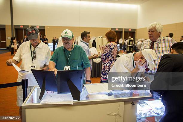 Guests look at items belonging to notorious Boston mobster James "Whitey" Bulger are displayed during before an asset-forfeiture auction in Boston,...