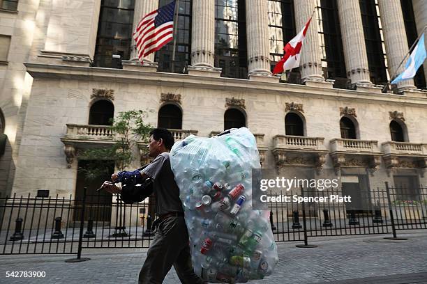 People walk by the New York Stock Exchange following news that the United Kingdom has voted to leave the European Union on June 24, 2016 in New York...