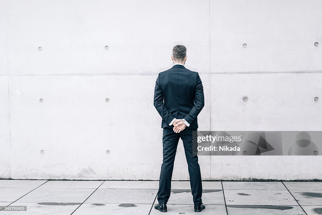 Businessman in front of a concrete wall