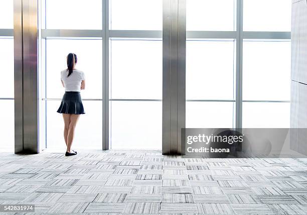 businesswoman looking through the window - office carpet stock pictures, royalty-free photos & images