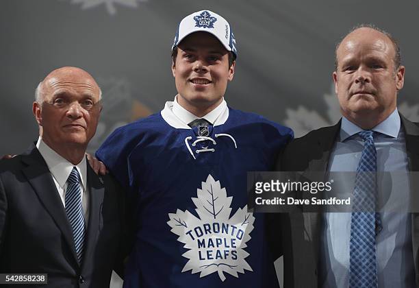 Auston Matthews poses onstage with general manager Lou Lamoriello, left, and director of player personnel Mark Hunter of the Toronto Maple Leafs...