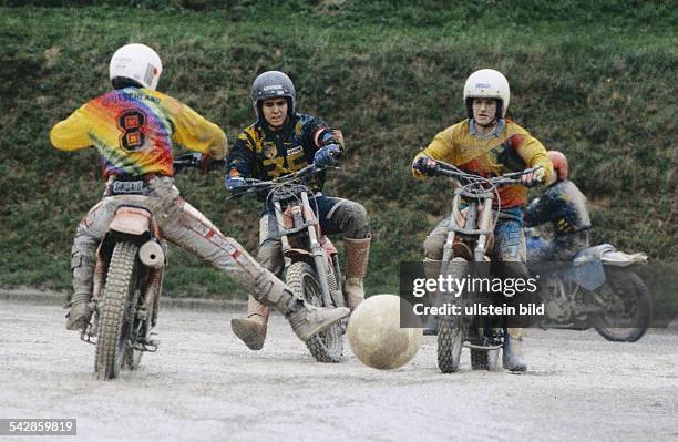 Drei Spieler gegnerischer Mannschaften auf ihren Motorrädern während der Motoball-Europameisterschaft 1994 in Baden . Der Spielball liegt zwischen...