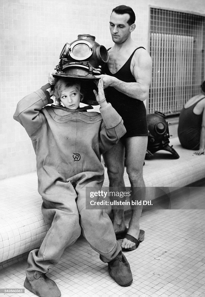 April fool hoax: Divers A diving instructor is helping a female diver to put on a diving helmet - 1933 - Vintage property of ullstein bild