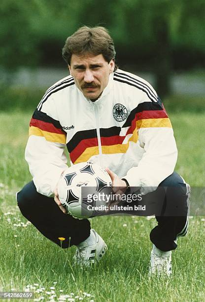 Der deutsche Fußballprofi Wolfram Wuttke im Trainingsanzug der Nationalmannschaft und dem Ball der Europameisterschaft von 1988. Aufgenommen um 1988