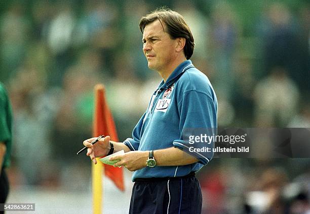 Ewald Lienen, Trainer des Fußball-Bundesligisten 1. FC. Köln, steht am Spielfeldrand. In der rechten Hand hält er einen Stift, in der linken einen...
