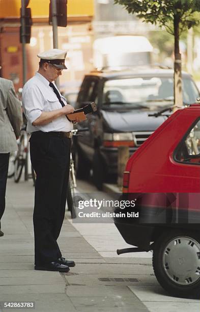 Ein Angestellter im Außendienst der Polizei kontrolliert Falschparker in der Hamburger Innenstadt. Strafmandat; Strafzettel; Verkehrssünder .