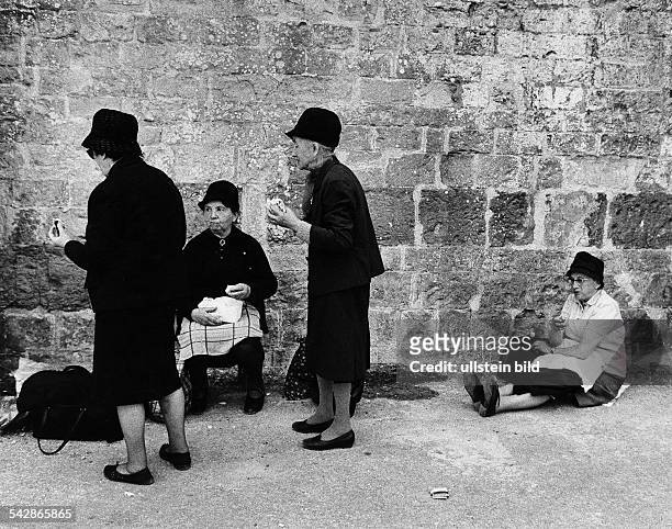 Alte Frauen bei einer Essenspause aneiner Steinmauer in Frankreich- Aufnahme ohne Jahr