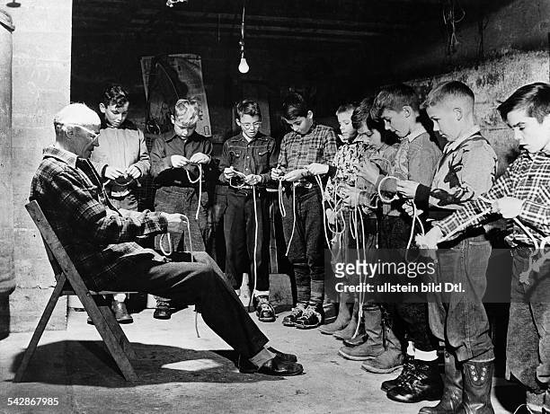 Originaltext: "Ein erfahrener 'Scoutmaster' unterweist die Jüngsten - die Club Scouts - in der Kunst des 'Knotens'." - 1952