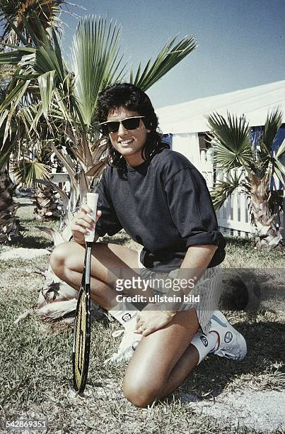 Die argentinische Tennisspielerin Gabriela Sabatini in Florida, wo sie ihren zweiten Wohnsitz unterhält. Sie kniet in einem Garten, im Hintergrund...