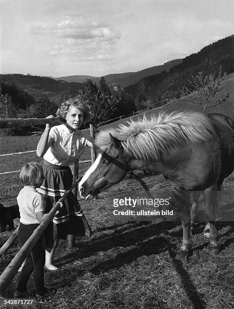 Ferien auf dem Lande im Schwarzwald: Eine Frau und ihr Kind streicheln ein Pony1966
