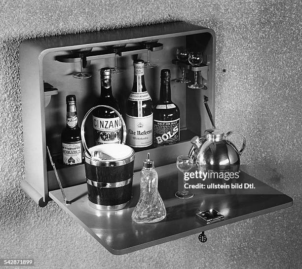 Eine "hängende" Hausbar mit Eisbehälter, Eiszange, Shaker in Kugelform und AngosturaträuflerModell von Küster und Perryveröffentlicht: Dame 25/1937