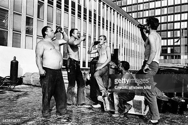 Bauarbeiter vor dem Verlagsgebäude des Axel-Springer-Verlages in der Kochstrasse. Die Männer mit nacktem Oberkörper trinken ein Pausenbier1967
