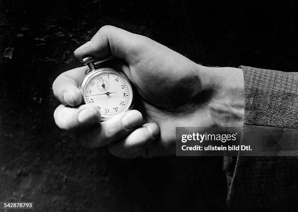 Eine Hand hält eine Stoppuhr- 1932