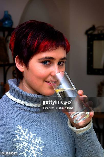 Frau trinkt ein Glas Mineralwasser.