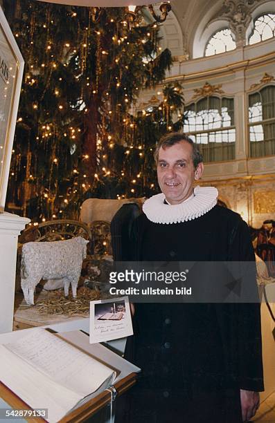 Der Hauptpastor der St.-Michaelis-Kirche, Helge Adolphsen, präsentiert das Michel-Gästebuch. Im Hintergrund ein festlich geschmückter Altar mit...