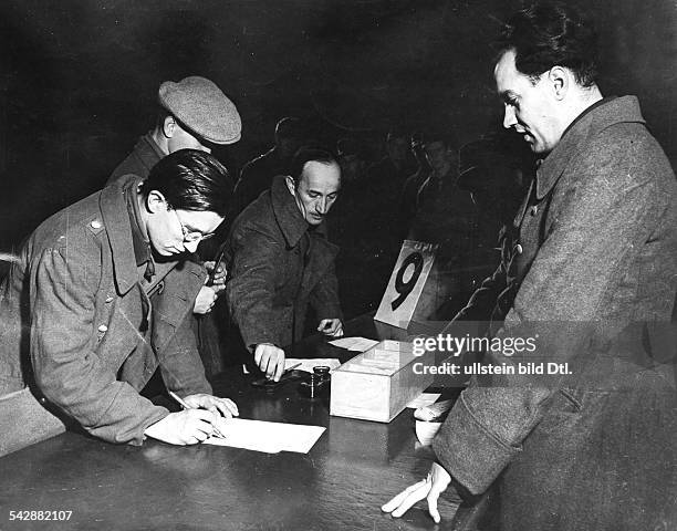 Entlassung von deutschen Kriegsgefangenen in der US-Zone in Bad Aibling: Unterschreiben des Entlassungsscheines- Februar 1946