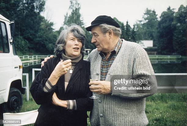 Der deutsche Showmaster und Entertainer Hans Joachim Kulenkampff mit seiner Ehefrau Traudel im Freien. Das Ehepaar hält Sektgläser in der Hand und...
