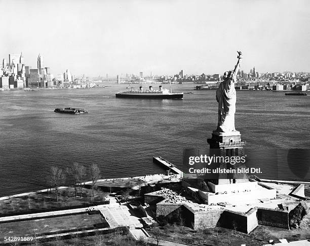 Das Passagierschiff Queen Mary fährt an der Freiheitsstatue vorbei, im Hintergrund die Skyline von Manhatten und Brooklyn- um 1960