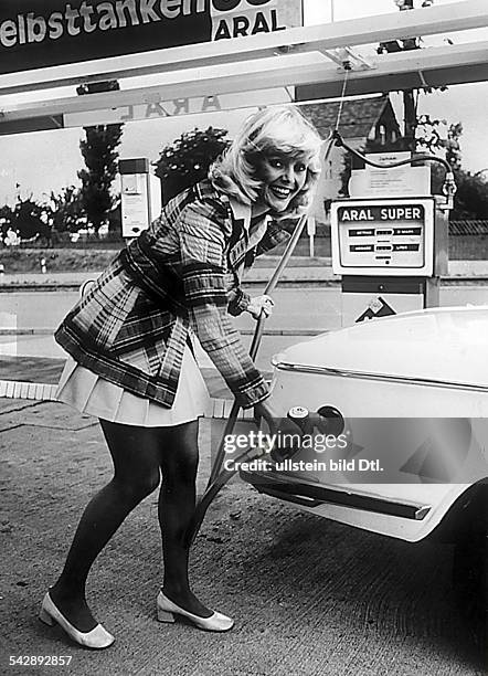 Junge Frau mit Minirock tankt an einerAral Selbsttankstelle.- 1973