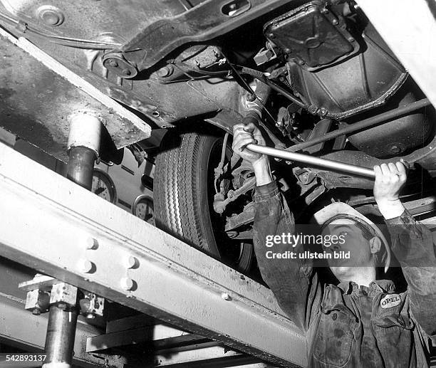 Mechaniker bei der Reparatur eines Autos in einer Werkstatt- 1968