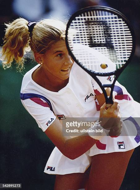Tennisspielerin Monica Seles beim beidhändigen Return. Sie trägt als Frisur einen Pferdeschwanz, ihr Tennisdress ist von FILA. Aufgenommen um 1991.