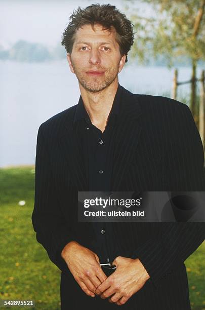 Der deutsche Schauspieler Rufus Beck im Grünen; er hat die Daumen in seinen Gürtel gehakt. Aufgenommen September 1998.