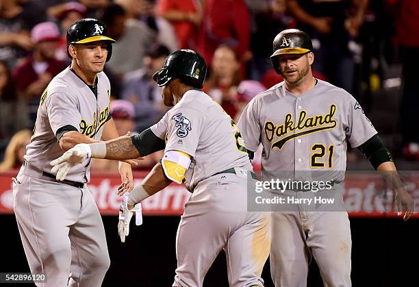 Khris Davis of the Oakland Athletics celebrates his three run homerun with Danny Valencia and Stephen Vogt to take a 7-4 lead over the Los Angeles...