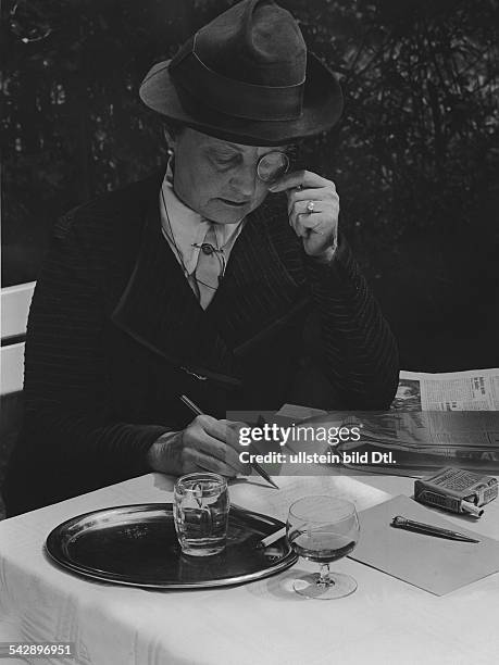 Ältere Frau mit Monokel schreibt am Cafehaustisch- 1939