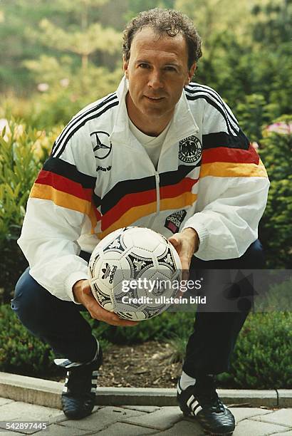 Franz Beckenbauer, Trainer der Deutschen Fußball-Nationalmannschaft, hält einen Fußball in den Händen. Beckenbauer trägt einen Trainingsanzug des...