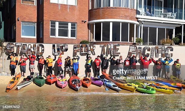 Group of kayakers, including members of Australia's Pacific islander community, hold up letters spelling out "stand up for the Pacific" after they...