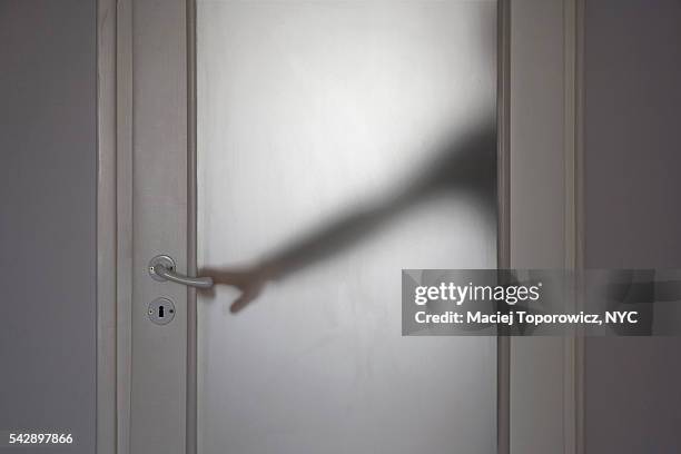 silhouette of a person trying to open translucent glass door. - individu étrange photos et images de collection