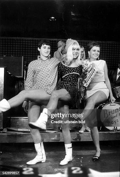 Erste Wahl der "Miss Minirock" im "New Eden Saloon" von Rolf Eden am Kurfürstendamm: drei Bewerberinnen heben ihre Beine hoch.September 1966