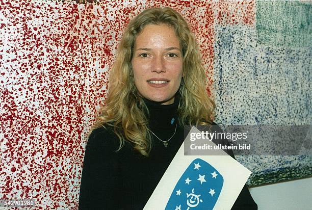 Jessica Stockmann, Ehefrau des ehemaligen Tennisprofis Michael Stich, hält das Logo der Michael-Stich-Stiftung in den Händen. Aufgenommen um 1999.