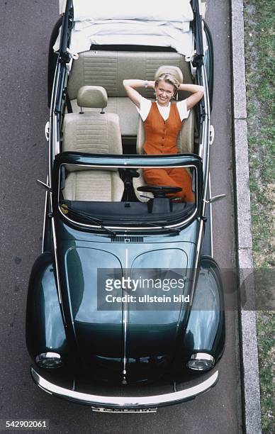 Die Fernsehredakteurin und Moderatorin Michaela Papke sitzt im offenen VW Käfer Cabrio und hat ihre Arme hinter dem Kopf verschränkt. Aufgenommen um...
