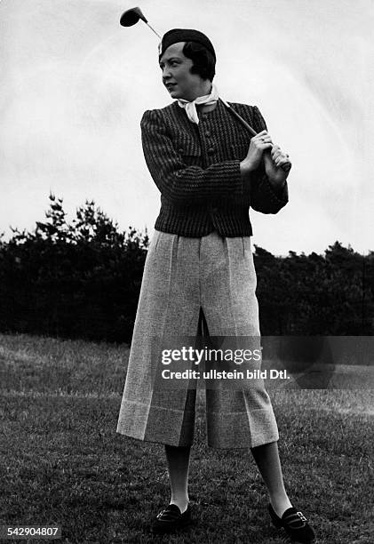 Hilde Riehl beim Golfspiel im grauen Flanell Hosenrock und einer kurzen rot-blauen Jacke im Hahnentrittmuster- erschienen: Dame 14/1934Aufnahme: Karl...