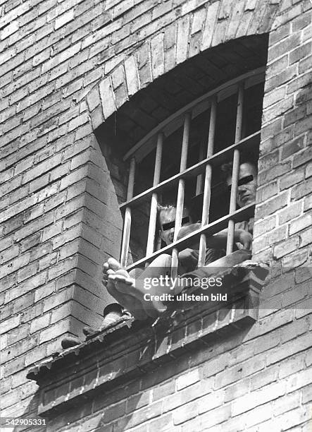 Strafanstalt Plötzensee in Berlin:zwei Häftlinge sitzen in ihrer Zelle am vergitterten Fenster und lassen die Füsse baumeln1966