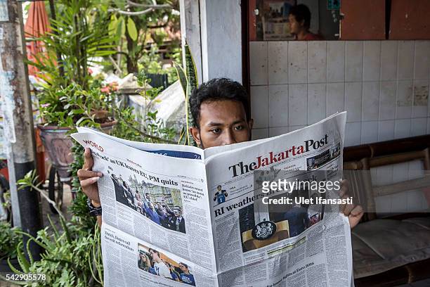 Man reads the Indonesian newspaper The Jakarta Post which shows the cover headline which reads 'RI weathers Brexit shock', on June 25, 2016 in...