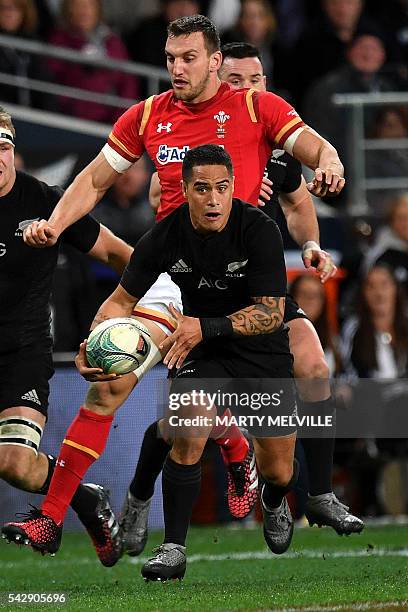 New Zealand's Aaron Smith runs with the ball as Sam Warburton of Wales gives chase during the third rugby union Test match between the New Zealand...