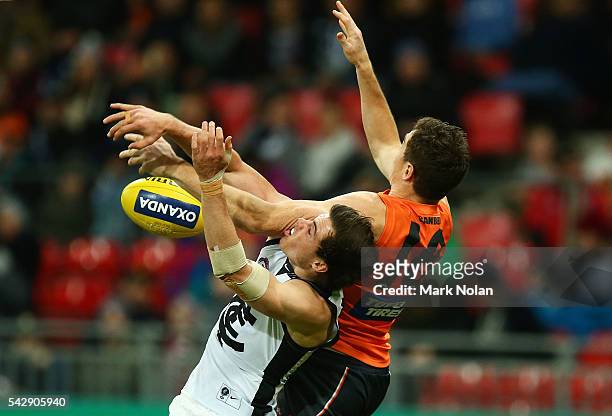 Lachie Plowman of Carlton and Jeremy Cameron of the Giants contest possession during the round 14 AFL match between the Greater Western Sydney Giants...
