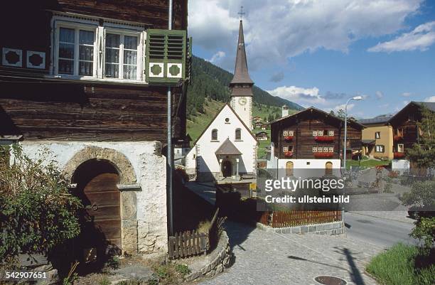 Der Dorfplatz in Biel, Kanton Wallis , mit der Kirche "Heiliger Johannes Evangelist''. Undatiertes Foto.