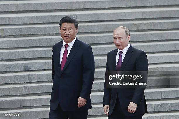 Chinese President Xi Jinping accompanies Russian President Vladimir Putin to view an honour guard during a welcoming ceremony outside the Great Hall...