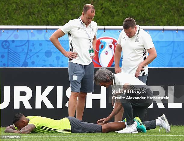 Jerome Boateng of Germany receives medical treatment from team doctor Hans-Wilhelm Mueller-Wohlfahrt during a Germany training session ahead of their...