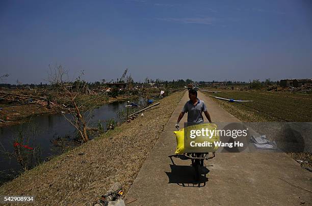 June 25: Villagers move food from collapsed houses in Danping Village of Chenliang Township in Funing, Yancheng, east China's Jiangsu Province, June...